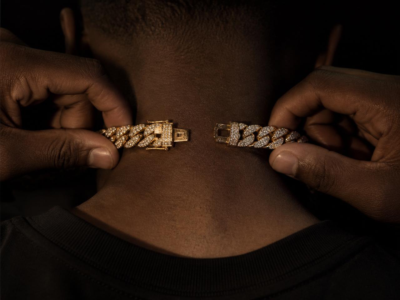 Iced-out Cuban link necklace being clipped on from behind